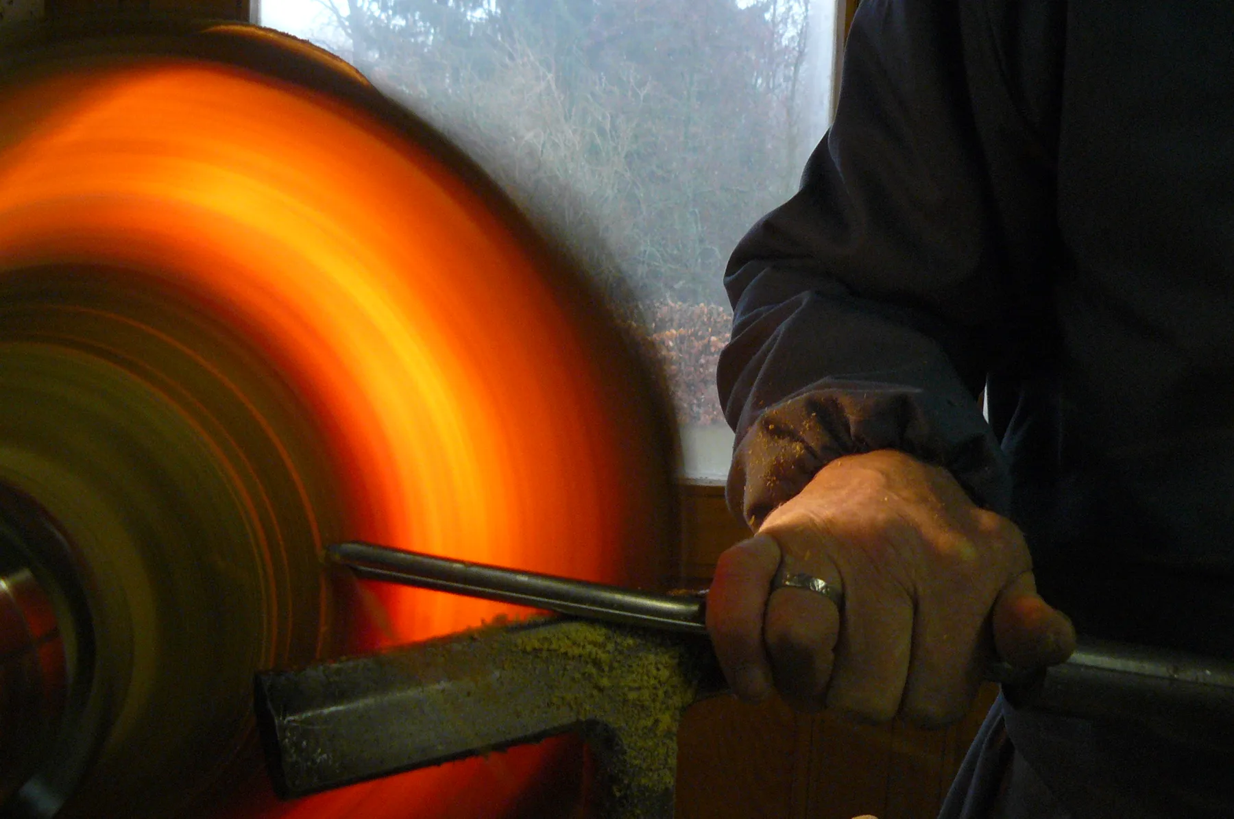 Paul Peeters tournant un abat-jour en bois vert rétroéclairé, atelier en Ardenne