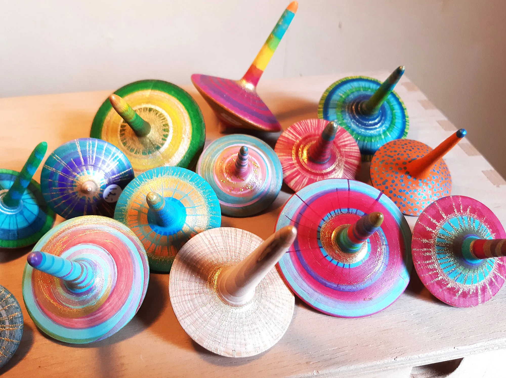 Collection de toupies en bois aux couleurs vives, tournées et peintes à la main